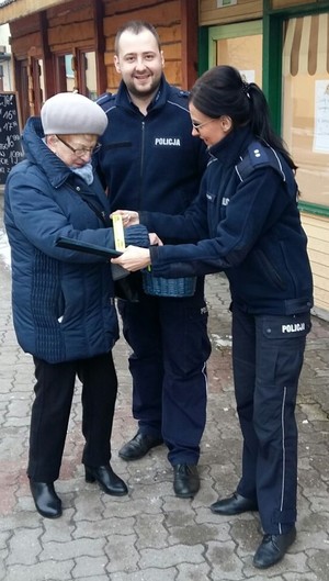 policjanci rozdający odblaski seniorom z okazji Dnia Babci i Dziadka