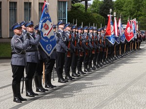 Kompania Honorowa Policji z szablami sztandarem i bronią stoją w pozycji na baczność