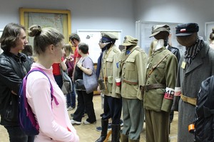 chłopak i dziewczyna podziwiają wystawę historycznych mundurów