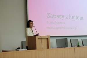 Kobieta przemawia do uczestników konferencji stojąc za mównicą