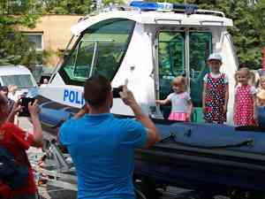 dzieci stoj na odzi policyjnej a rodzice robi im zdjcia