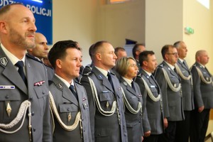 Kadra kierownicza wielkopolskiej Policji stoi w galowych mundurach w rzędzie