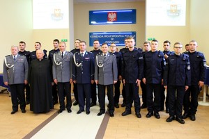 Komendant Wojewódzki Policji w Poznaniu wraz z zastępcami pozuje do grupowego zdjęcia z nowo przyjętymi policjantami