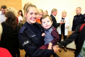 Policjantka trzyma na rkach mae dziecko
