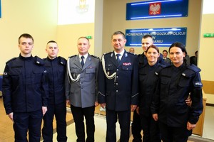 Komendant Wojewódzki Policji w Poznaniu pozuje do grupowego zdjęcia z nowo przyjętymi policjantami
