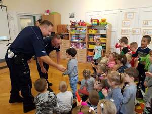 Policjanci w mundurach na spotkaniu z dziećmi w przedszkolu