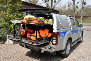 Policyjny radiowóz terenowy - zdjęcie bagażnika wypchanego sprzętem ratowniczym.