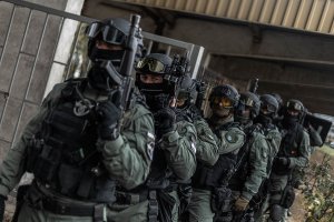 Policjanci z Grupy Realizacyjnej KMP w Poznaniu w trakcie szkolenia ćwiczą pod czujnym okiem instruktorów strzeleckich obezwładnienie napastnika.